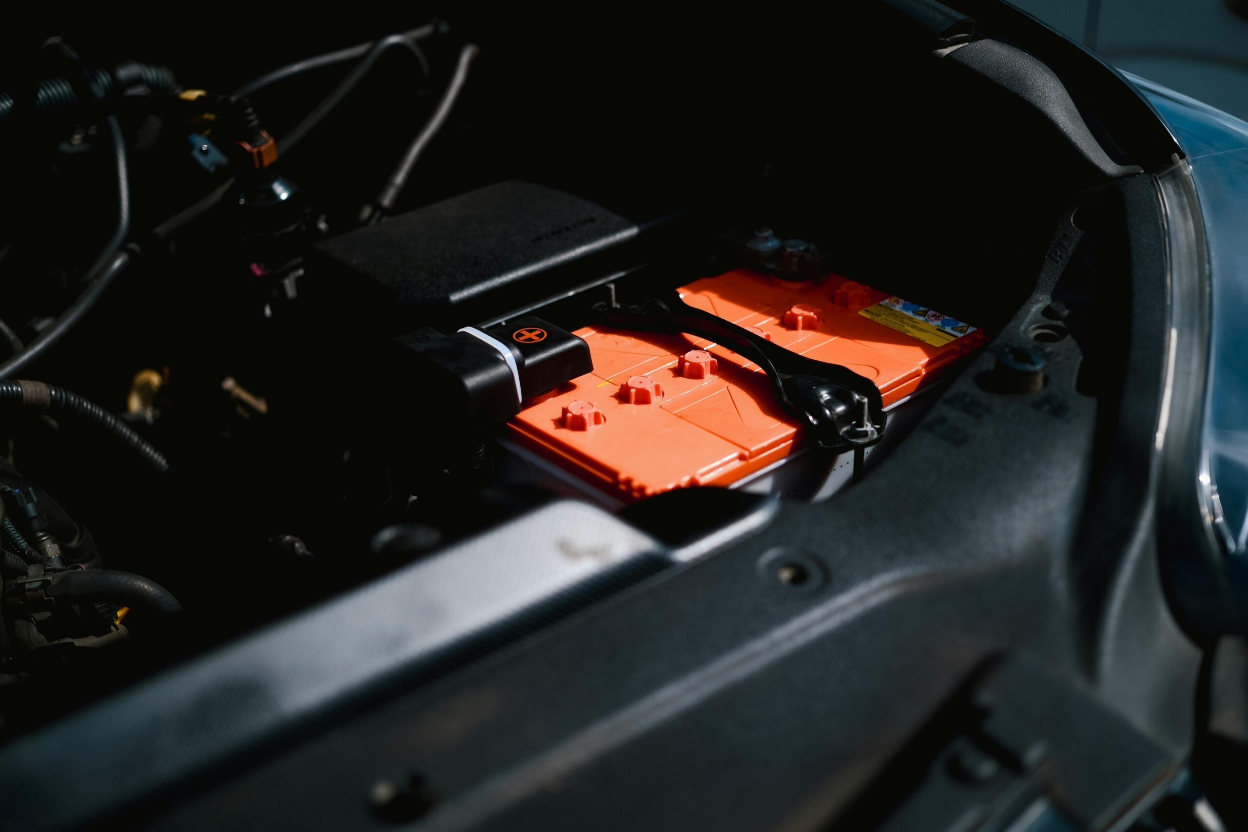 Detailed view of an electric car battery inside a vehicle's engine compartment, highlighting sustainable technology.